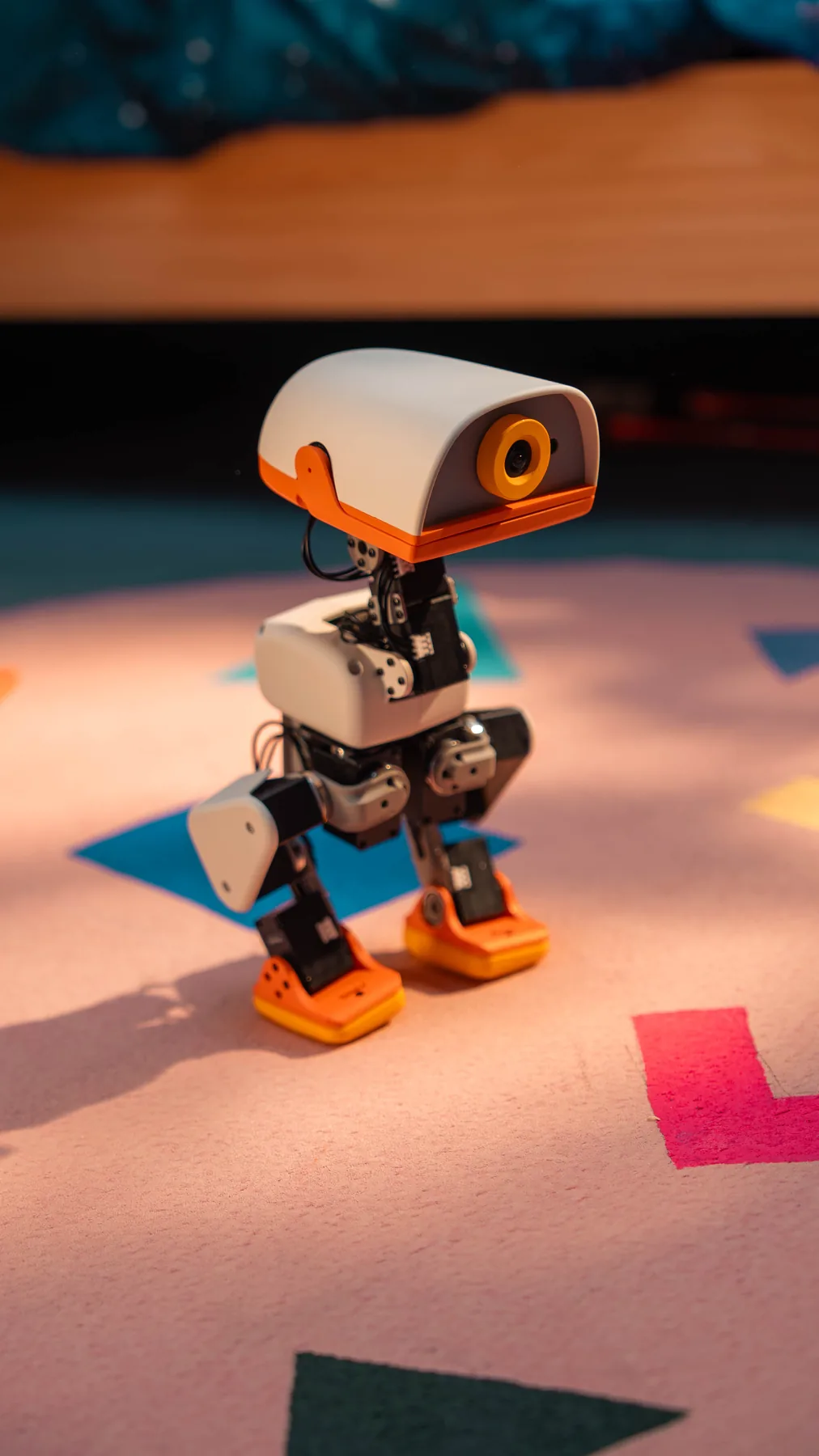 A MACRODUCK standing on a pink rug in a child's playroom